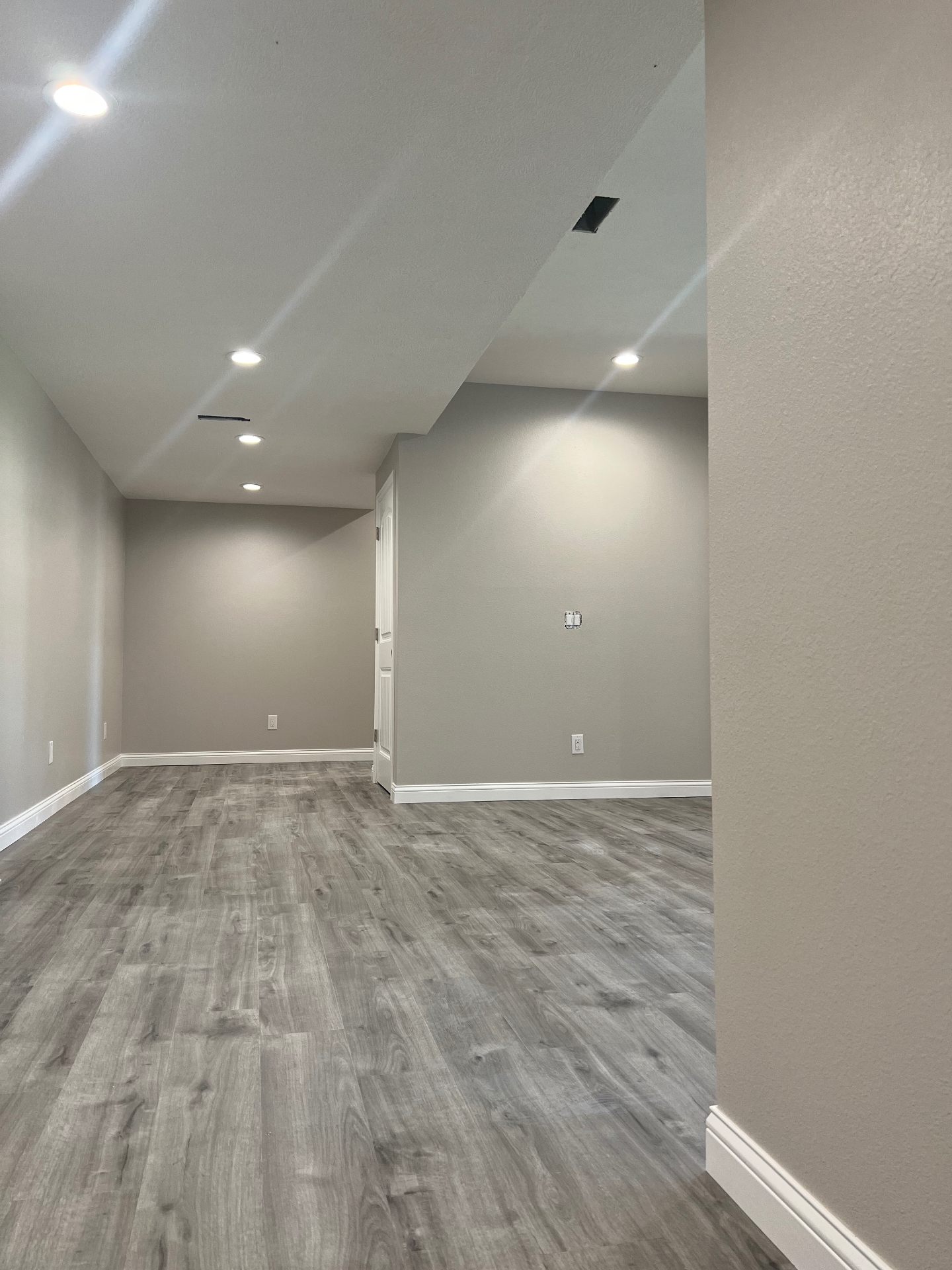 Basement living area and hallway in modern greige — Springfield, MO