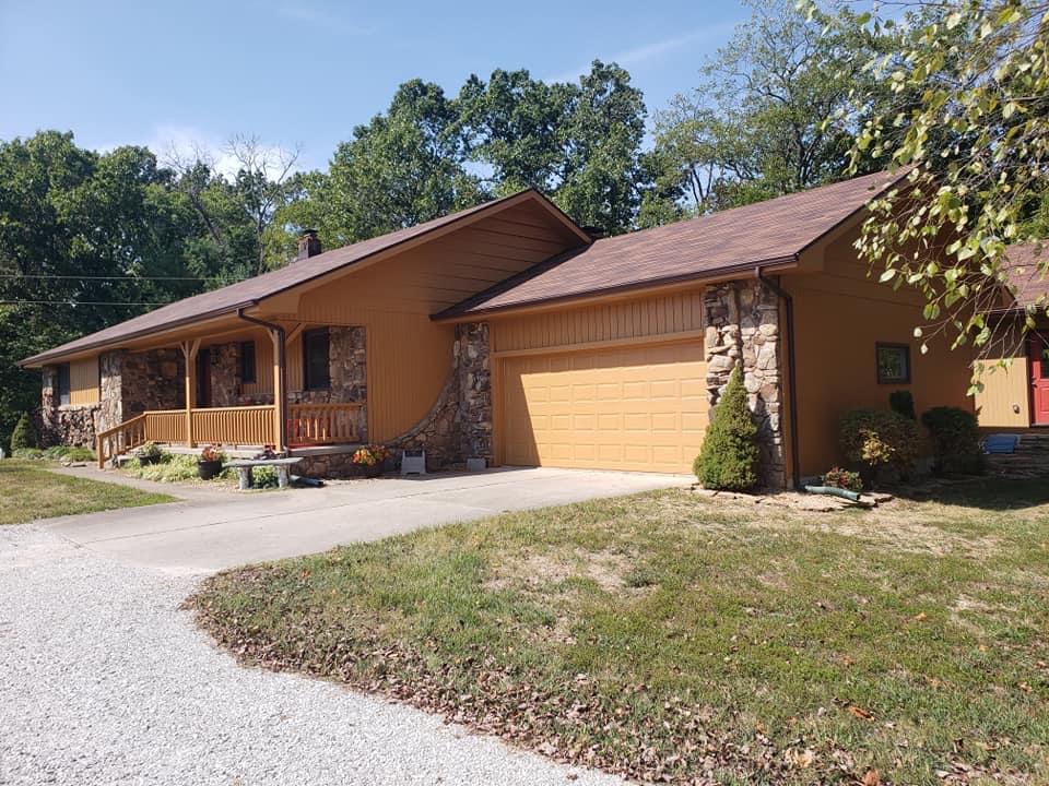 Exterior house painting in Strafford, MO — ranch home repainted in warm ochre